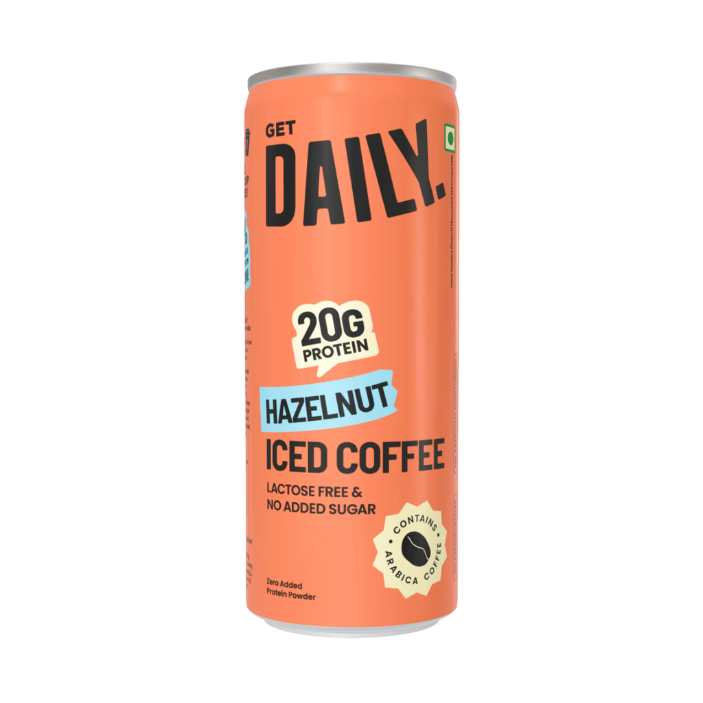An orange can of Get Daily Hazelnut Iced Coffee protein powder, featuring bold black text, a light blue 'HAZELNUT' banner, and a gold badge indicating 20g protein.