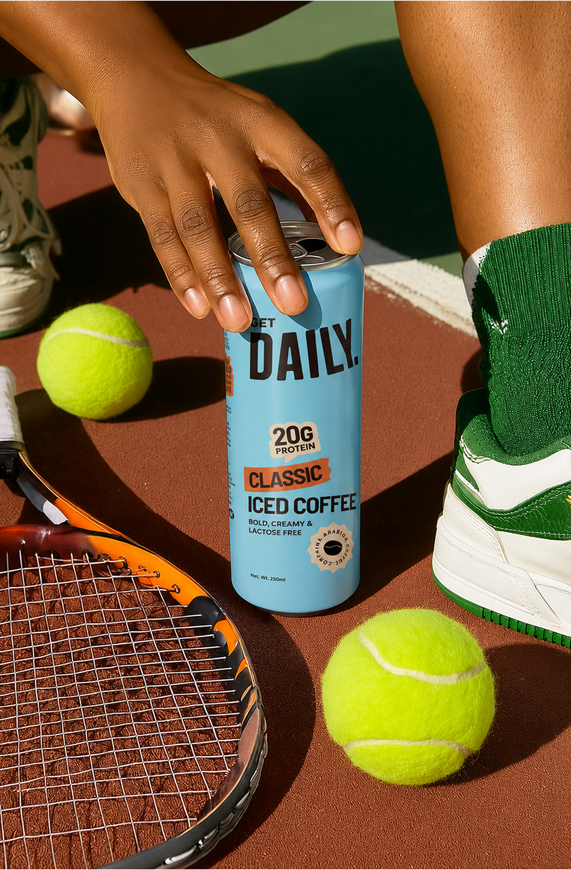 Get Daily iced coffee can on a tennis court